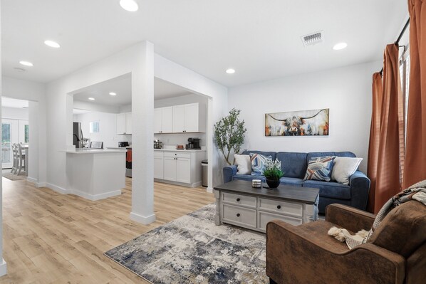 A modern living room with a sofa, coffee table, and a rug.