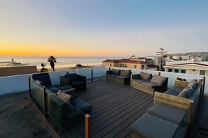 A rooftop terrace with outdoor seating and a view of the ocean at sunset. - RMB I: Island Beach Condo; 2Br, Sleeps 6-10 (San Diego)