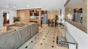Ein modernes Wohnzimmer mit einer Couch, einem Essbereich und einer Küche im Hintergrund.