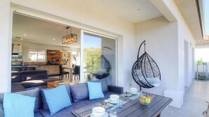 An open-plan living area with a sofa set, dining table, and a hanging chair. - Le Spurtone - ALATA - Gîte (ALATA)