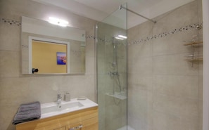 A modern bathroom with a glass-enclosed shower, a sink with a mirror above, and a towel on the counter. - A Sàpara - CHISA - Gîte (CHISA)