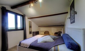 A bedroom with a bed, a chair, a desk, and a window with curtains. - Tra Mare e Tova - SOLARO (SOLARO)