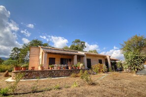 A two-story house with a stone foundation, a tiled roof, and potted plants in the front yard. - Tra Mare e Tova - SOLARO (SOLARO)