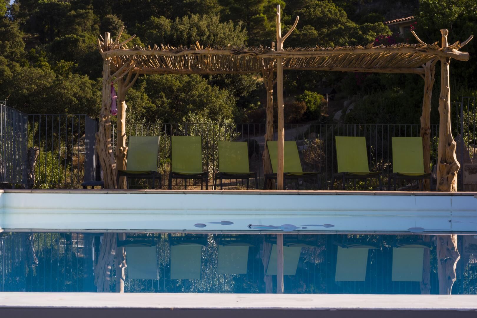 Una piscina con un porche de madera y sillas.