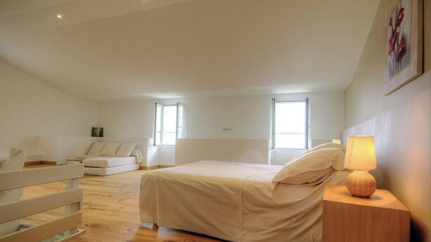A bedroom with a bed, a nightstand, a lamp, a window, and a sofa. - Little paradise - ROGLIANO (ROGLIANO)