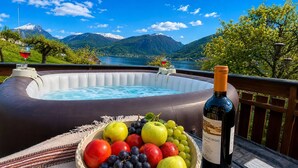 Un jacuzzi con una botella de vino y un bol de fruta.