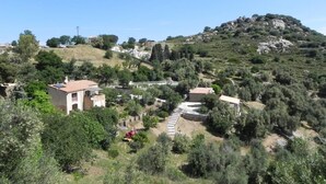 Paisaje rural con casas, una colina y cielo despejado.