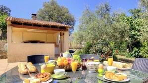 An outdoor breakfast setup with a table, chairs, and a variety of food and drink items. - Santa Maria - PIETRALBA (PIETRALBA)