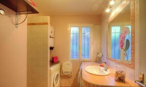 A bathroom with a washing machine, a sink, a mirror, and a window with frosted glass. - A Gavera - ROGLIANO - Guest house (ROGLIANO)