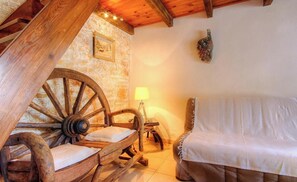 A rustic room with a wooden bed, a stone wall, and a large wooden wheel structure. - I Pagliaghji - BISINCHI (BISINCHI)