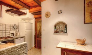 A kitchen with a stove, refrigerator, and a stone counter. - I Pagliaghji - BISINCHI (BISINCHI)