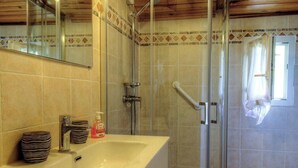 A bathroom with a glass shower enclosure, a sink with stacked bowls, and a mirror. - A Casa Vecchia - LUCCIANA (LUCCIANA)