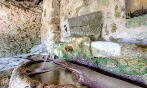 Ein Steine Wasserspiel mit einer Quelle und einem kleinen Becken.