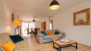 Ein Wohnzimmer mit einer Couch, einem Couchtisch und einem Essbereich mit Stühlen und einem Tisch.