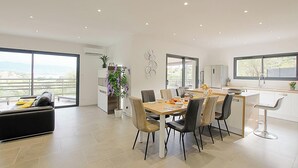 Une cuisine moderne avec un coin repas, une grande fenêtre et un balcon offrant une vue dégagée.