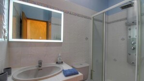 A bathroom with a sink, mirror, toilet, and shower. - Les oliviers 1 - SOLLACARO (SOLLACARO)