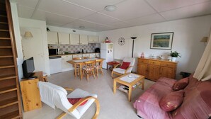 A compact living space with a kitchenette, dining area, and a sofa. - Nice holiday house, 3 bedrooms, AIRCO upstairs, a secured residence with pools,slides. Wifi, at... (PORTIRAGNES)