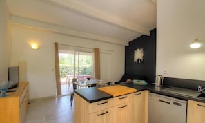 A compact kitchen with a dining area, a large window, and a black accent wall. - A mini villa with swimming pool less than 5 kilometers from the beach (PORTO VECCHIO)