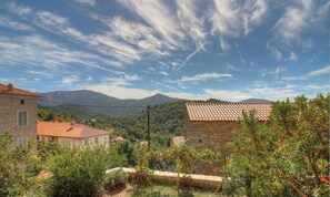 A rural landscape with stone buildings, a clear sky, and mountains in the background. - U Castagnu 1 - EVISA (EVISA)