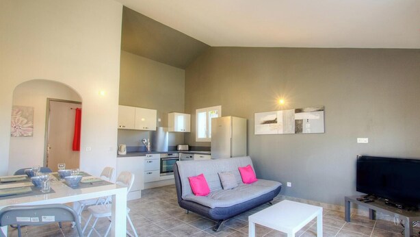 A compact living space with a kitchenette, a dining area, a sofa, and a television. - Ricarulu - CONCA - Gîte (CONCA)