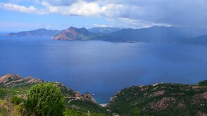 Un paisaje costero con vistas al mar, montañas y un cielo despejado.