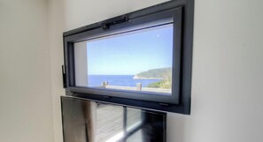 Ein Fenster mit Blick auf das Meer und die Klippen.