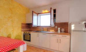 A kitchen with a stove, oven, sink, and refrigerator. - Bleuet - SARTENE - Gîte (SARTENE)