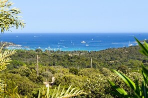 A coastal landscape with a view of the sea, boats, and a hilly terrain with vegetation. - Casa Ghjulia - PORTO VECCHIO (PORTO VECCHIO)