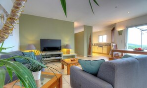 A living room with a sofa, television, and plants. - Casa Ghjulia - PORTO VECCHIO (PORTO VECCHIO)