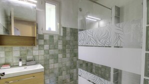 A bathroom with a sink, mirror, and tiled walls. - The holm oaks - CONCA (CONCA)
