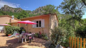 A house with a patio, outdoor furniture, and a wooden fence. - The holm oaks - CONCA (CONCA)