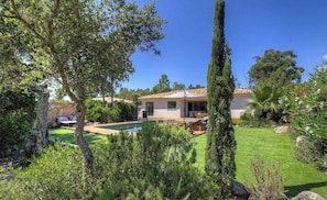 Ein Haus mit Swimmingpool, Terrasse und Garten.