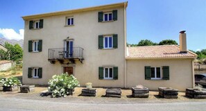 A two-story building with a balcony, multiple windows with shutters, and a chimney. - Cuccia - CORSCIA - Guest house (CORSCIA)