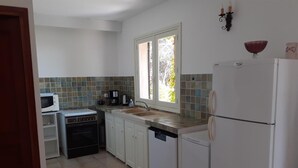 A compact kitchen with a microwave, stove, sink, and refrigerator. - I dui cipressi - BASTELICACCIA (BASTELICACCIA)