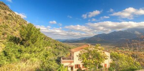 A rural house with a red roof, surrounded by greenery and mountains. - Anne-Lise - AVAPESSA (AVAPESSA)