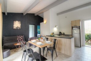 Eine moderne Küche mit Backofen und einer Essecke mit Tisch und Stühlen.