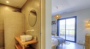Un baño moderno con lavamanos independiente, espejo y cabina de ducha.