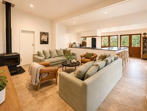 Ein geräumiger Wohnbereich mit einer Sofagarnitur, einem Couchtisch und einem Kamin.