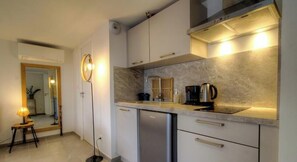 A modern kitchen with a dishwasher, a coffee maker, and a kettle on the counter. - Casa S - Lilina - TRALONCA (TRALONCA)