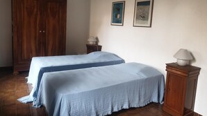 A bedroom with two beds, a wooden wardrobe, and two wall-mounted lamps. - U Monte - MONTICELLO (MONTICELLO)