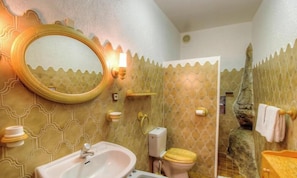 A bathroom with a sink, toilet, and mirror, featuring patterned walls and a decorative door. - U Monte - MONTICELLO (MONTICELLO)