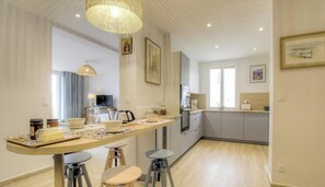A modern kitchen with a central island, bar stools, and a dining table. - Cours Napoleon - AJACCIO (AJACCIO)