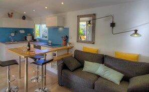 A modern kitchen with a dining area, a sofa, and a bar stool. - U rustincu - CALENZANA (CALENZANA)