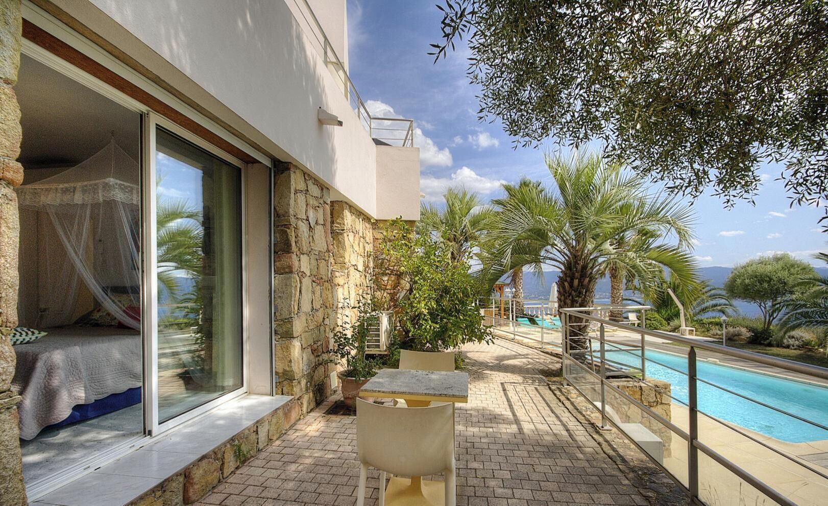 A balcony with a pool, stone walls, and a bed with a canopy.