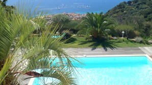 Una piscina con vistas al mar y a la costa lejana.