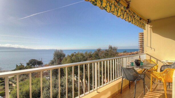 Ein Balkon mit Meerblick, einem Tisch und Stühlen sowie einem Geländer.