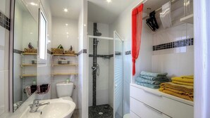 Ein modernes Badezimmer mit Duschkabine aus Glas, einem weißen Waschbecken und ordentlich gefalteten Handtüchern.