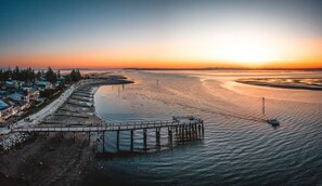 A coastal town with a pier extending into calm waters, surrounded by residential buildings. - 2BR Surrey Pool Suite Near White Rock (Surrey)