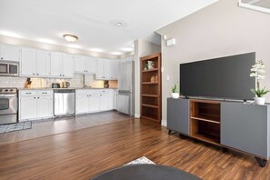 A modern kitchen with white cabinets, a microwave, and a coffee maker. - 2BR Surrey Pool Suite Near White Rock (Surrey)