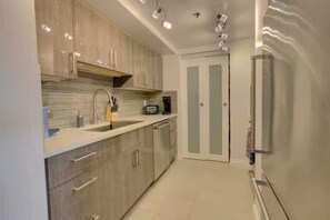 Una cocina moderna con microondas integrado, un lavaplatos y un refrigerador.